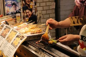 שף מורח רוטב סויה על שיפוד בשוק נישיקי מרקט קיוטו